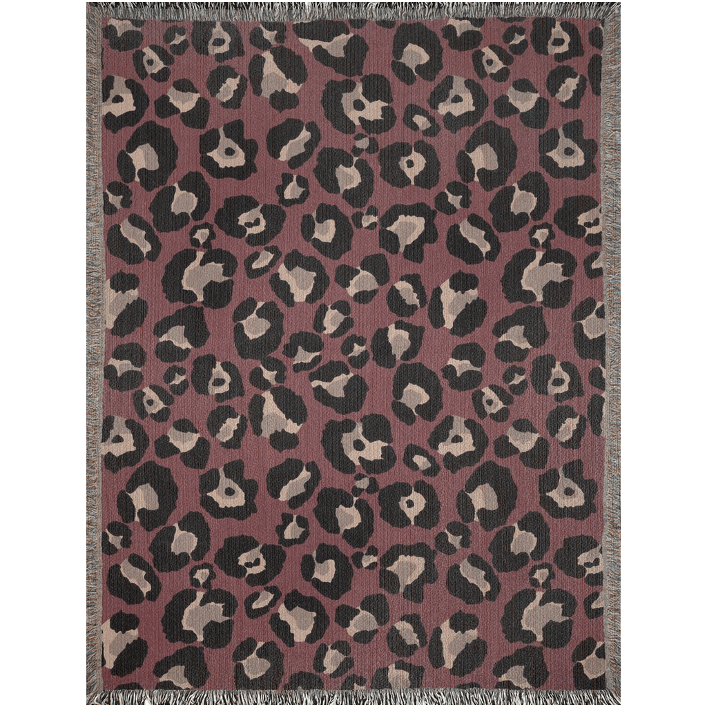 Bold burgundy woven throw blanket featuring leopard print with fringed edges, perfect for stylish decor.