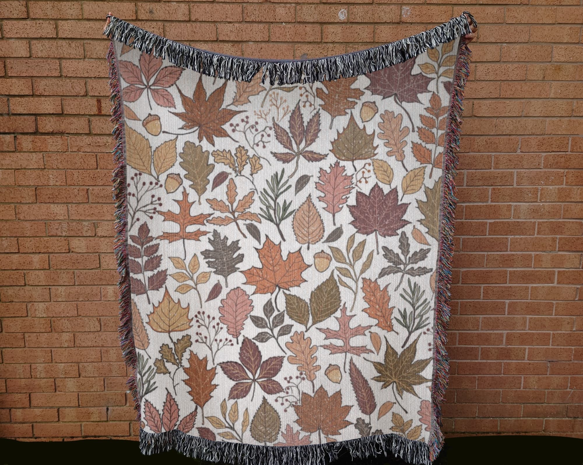 Fall woven blanket with cream background draped over couch