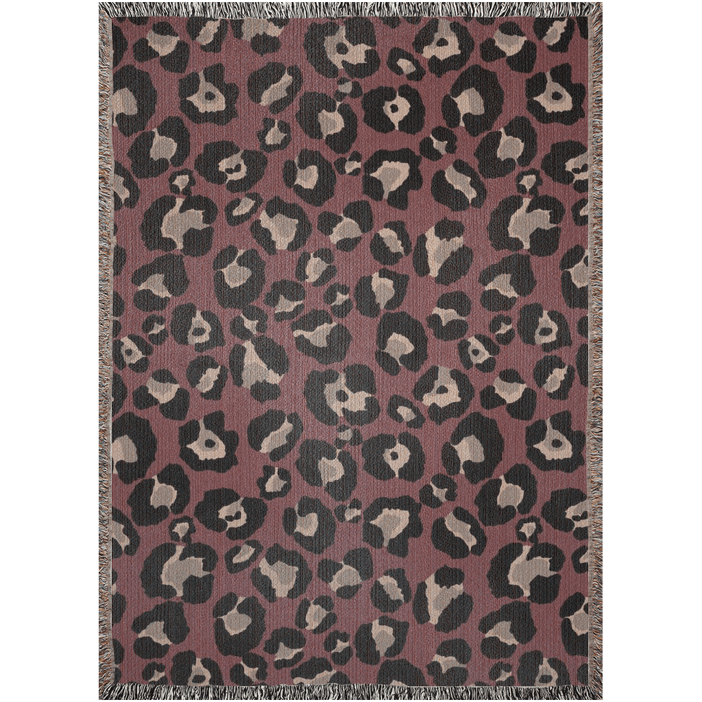 Woven throw blanket featuring bold leopard print in burgundy and black, with fringed edges, perfect for maxmimalist decor.