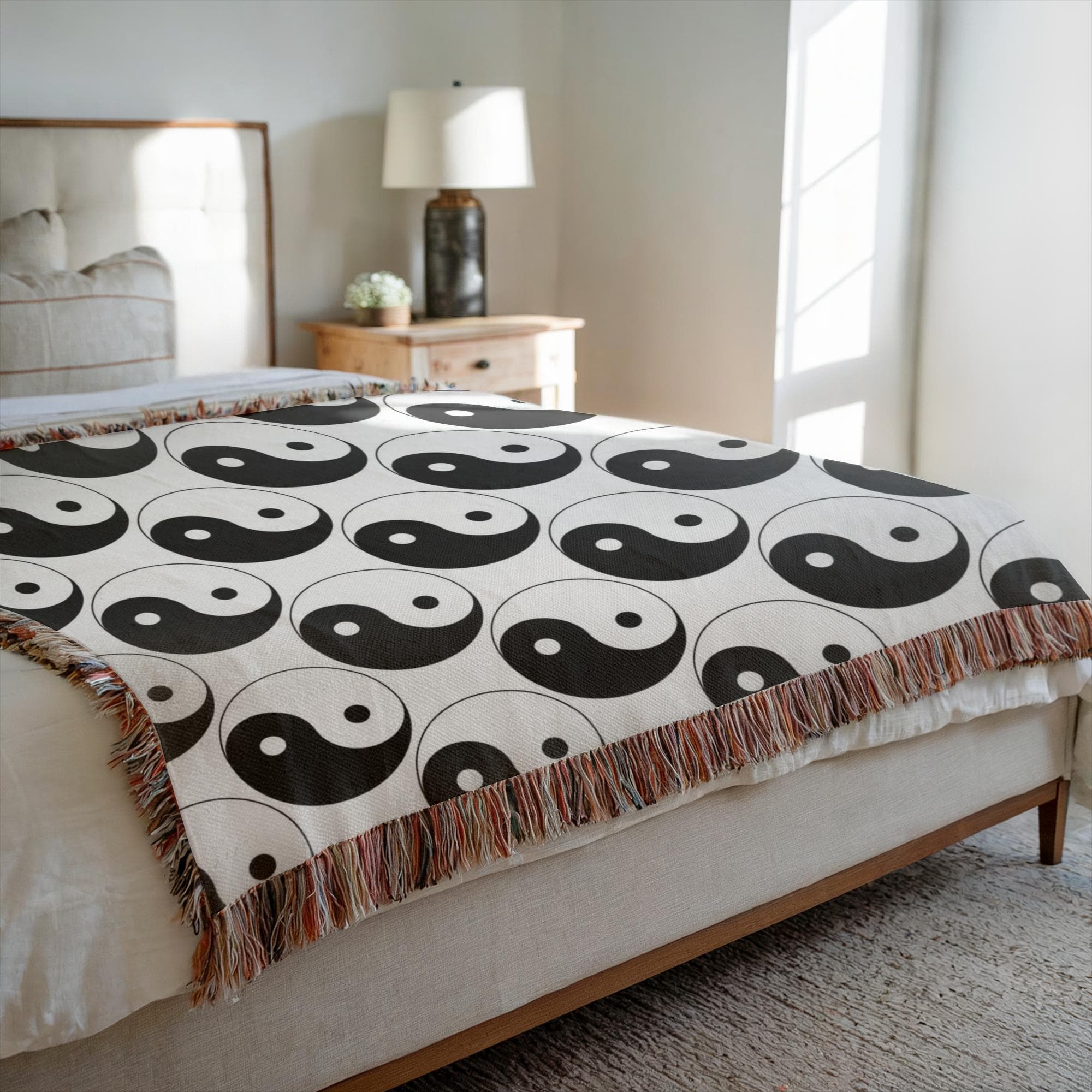 Yin yang woven blanket draped over bed for spiritual boho decor