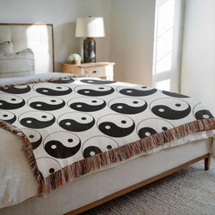 Yin yang woven blanket draped over bed for spiritual boho decor