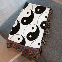 Fringe and texture detail of yin yang woven blanket folded neatly