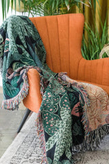 Tropical leaf botanical woven blanket throw in a plant-filled room