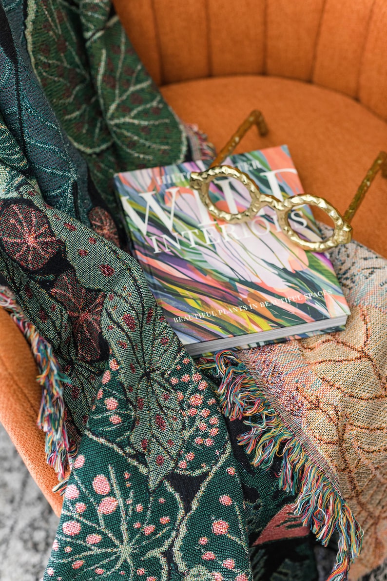 Botanical woven boho blanket with multicolor fringe detail in use during cozy reading moment